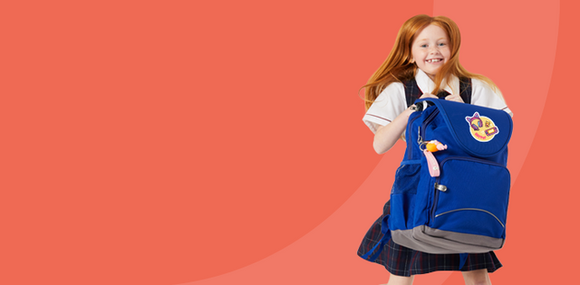 Happy Australian girl jumping with blue school bag
