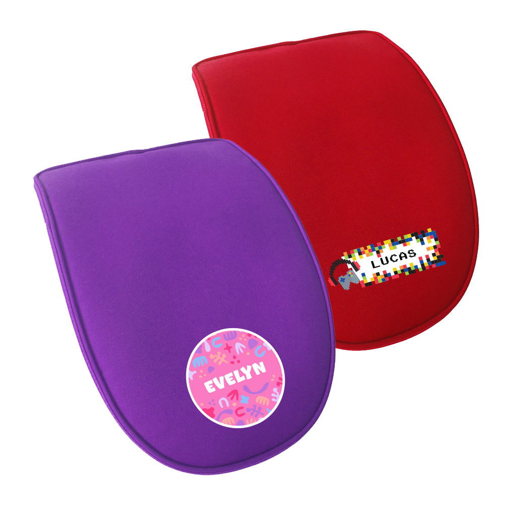 Close up view of two detachable single ergo flaps in different colours. The front flap is in purple with an abstract personalisation. The flap behind is in red with a pixel namebar personalisation.