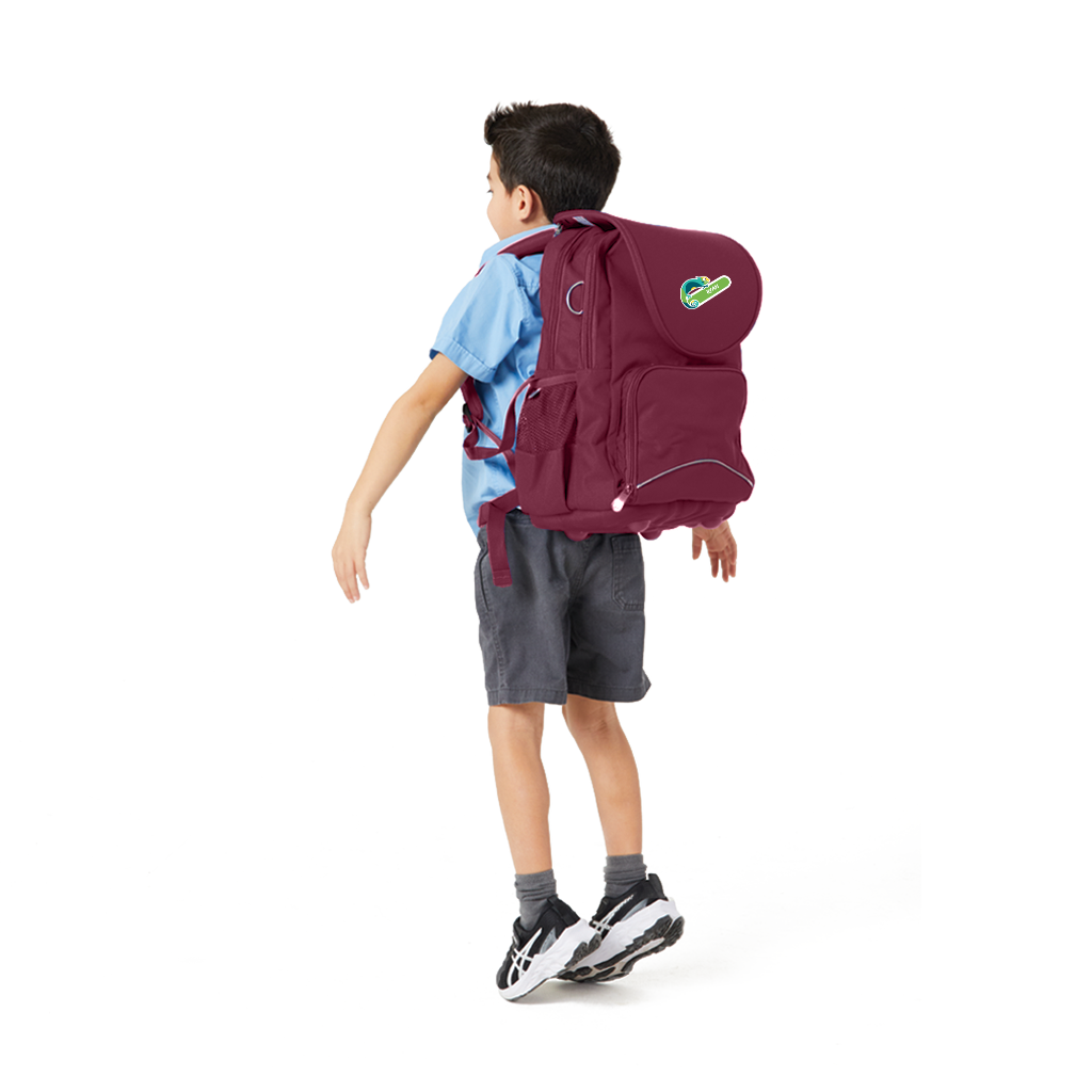 7 year old model in school uniform wearing on his back the Harlequin Posture Primary Backpack in maroon with personalisation.