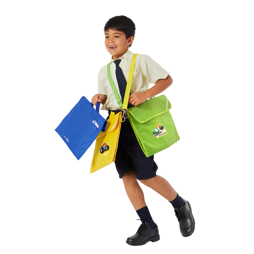 7 year old child model in school uniform carrying across his shoulders a yellow and an apple green safety library bag with personalisation and in his hand a royal blue safety library bag.