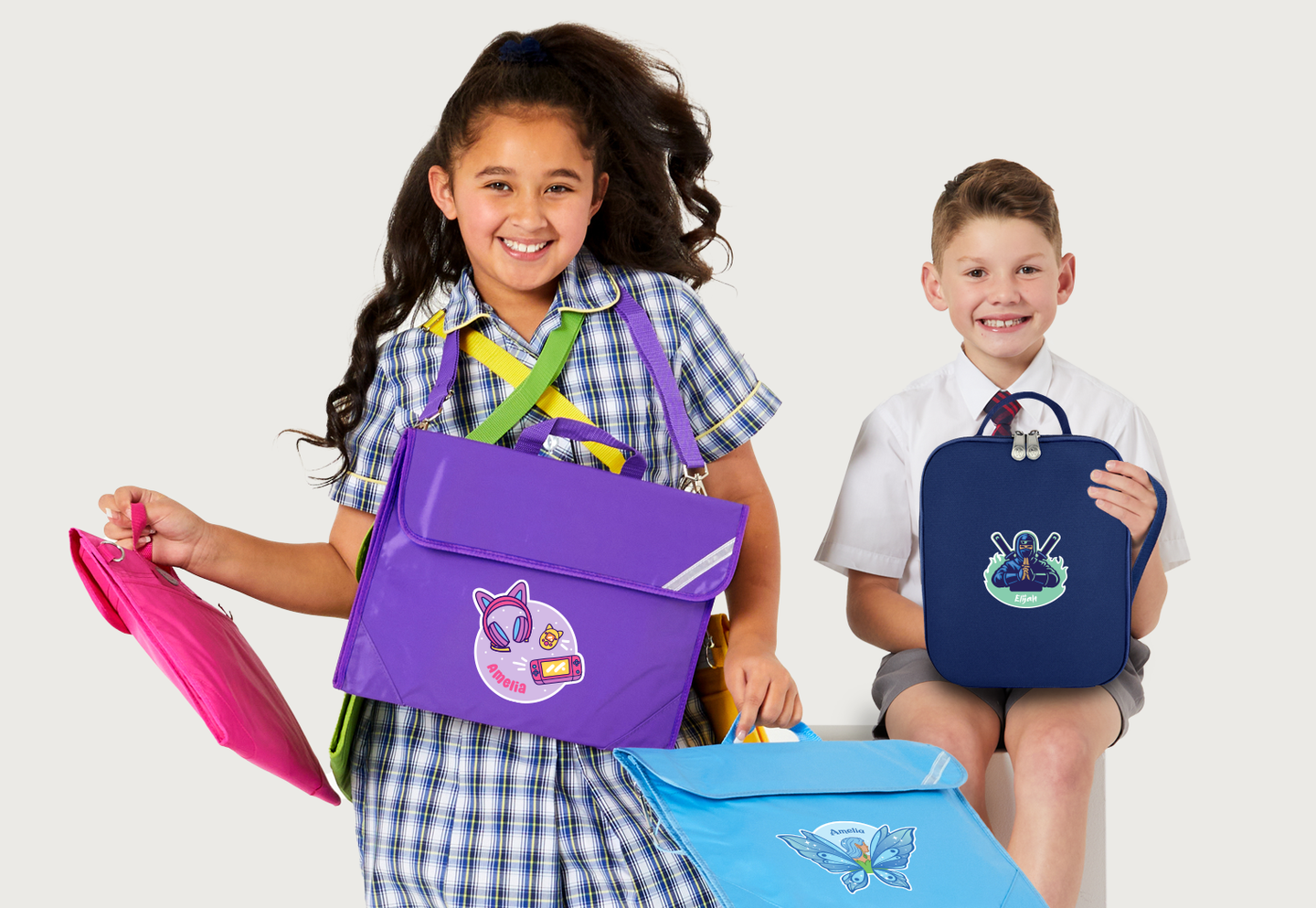 Boy and girl in school uniform with book bags and lunch bags ready for school