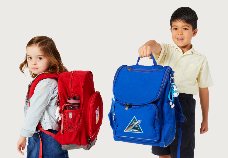 Three year old girl wearing a red Harlequin Kindy Backpack and a seven year old boy holding a Royal Blue Harlequin Mighty Backpack.