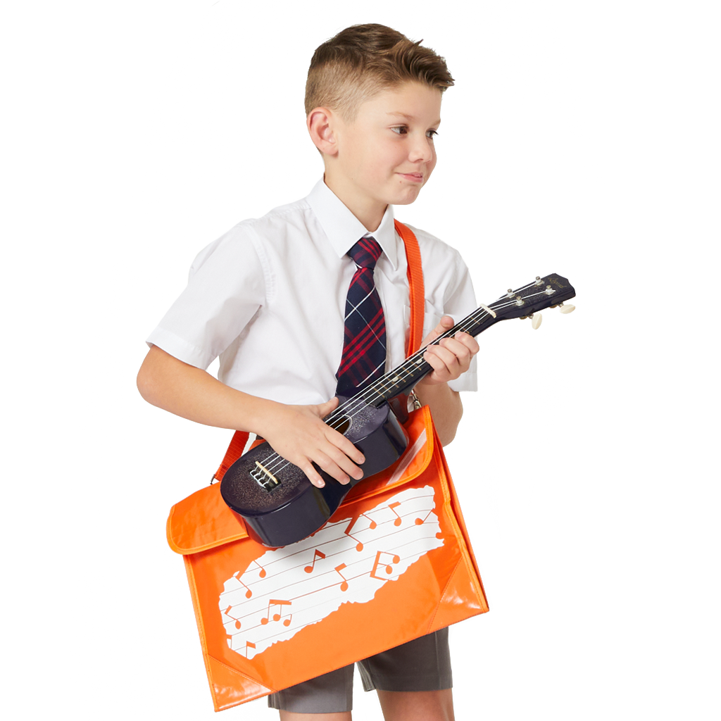8 year old child model in school uniform holding a little ukulele, whilst wearing over his shoulder the Harlequin Quartet Melody Music Bag in orange with pre-printed with a Melody motif.