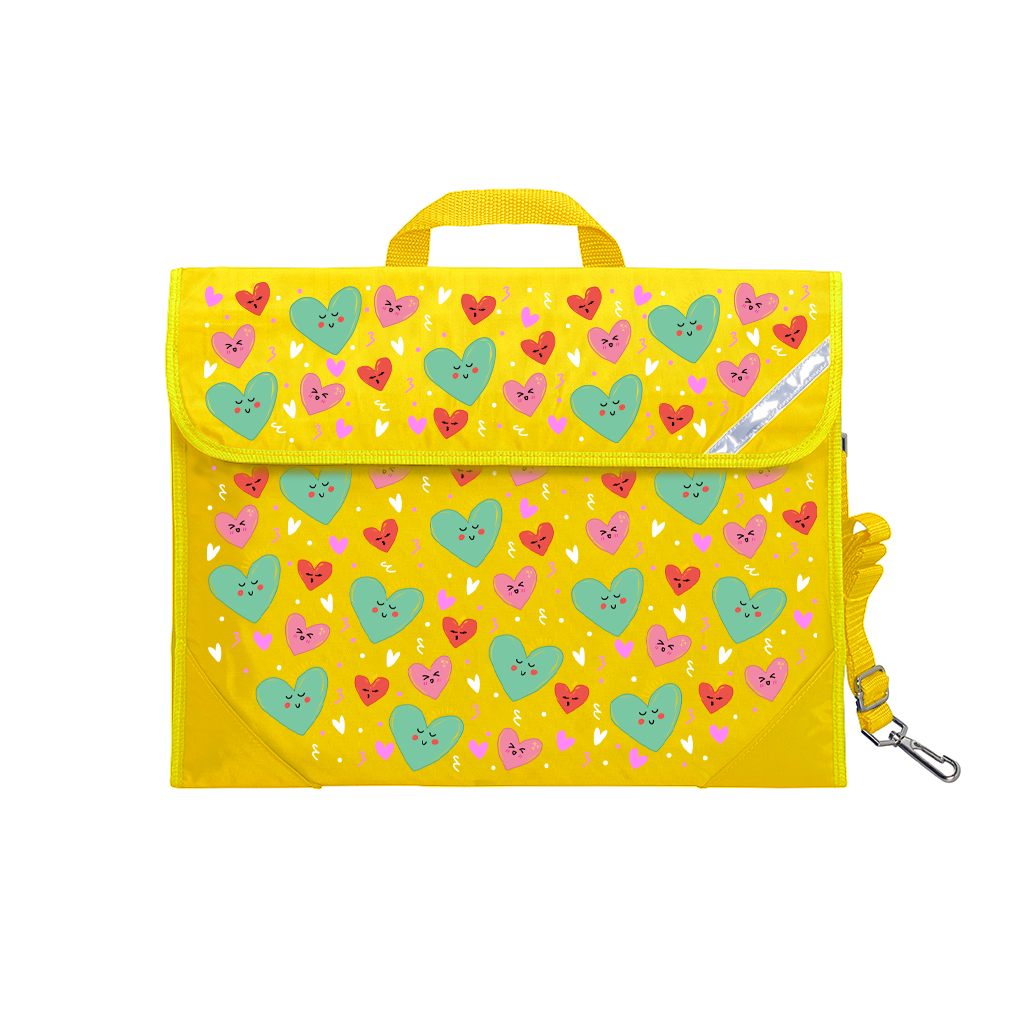 Harlequin Safety Library bag in Yellow with Sweet Hearts design from the Harlequin Creatix Signature Series. Front view displaying carry handle, easy open velcro strap, reflector safety strip, reinforced corners and shoulder strap.