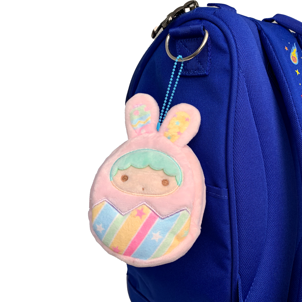 Plush keychain with pastel colors attached to a blue backpack