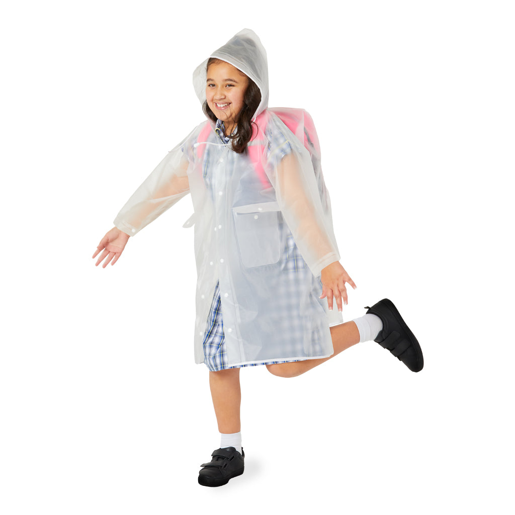 School girl smiling and wearing a transparent raincoat with a hood on a white background.