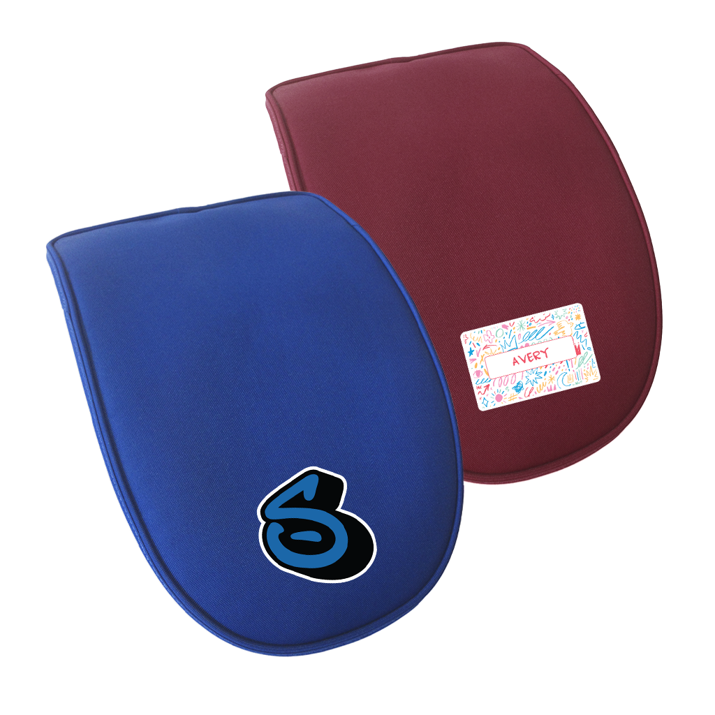 Close up view of two detachable single ergo flaps in different colours. The front flap is in royal blue with a letter personalisation. The flap behind is in maroon with a scribble art namebar personalisation.