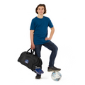 14 year old child model in casual clothing, holding in his right hand the Harlequin Large Sports bag in black with personalisation. 